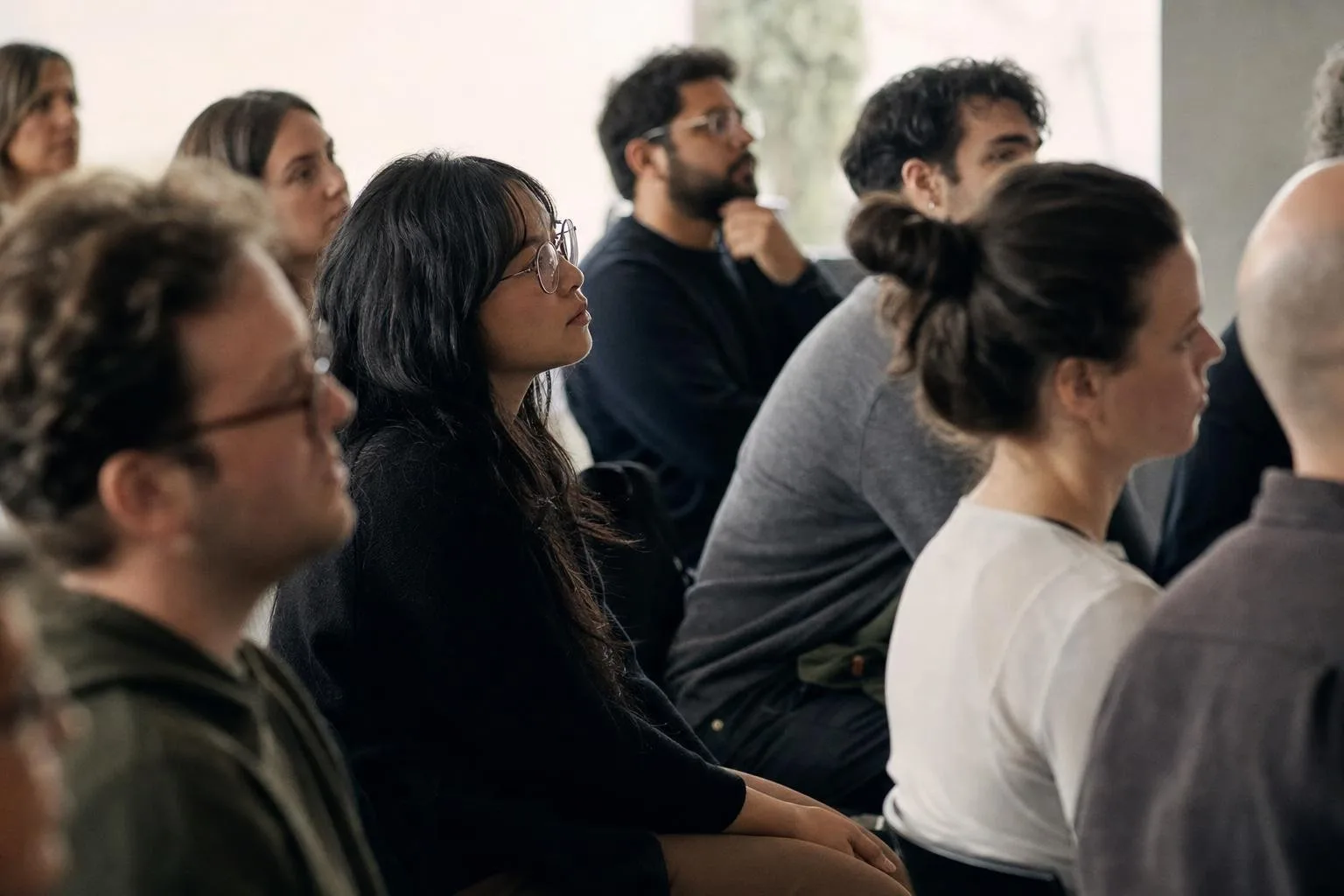 A warm, packed room of developers listening to a speaker at an evening meetup